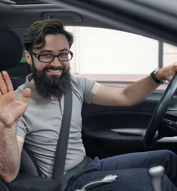 happy-car-driver-with-fastened-seat-belt-waving